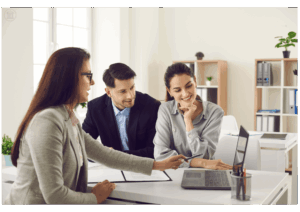 Conseiller financier discutant avec un couple de clients des solutions de rachat de crédit pour simplifier ses mensualités.