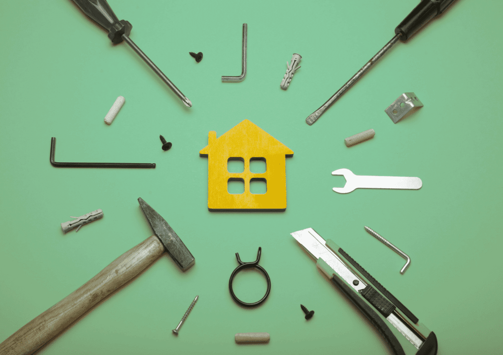 Solutions financement travaux maison : outils de bricolage et maquette de maison