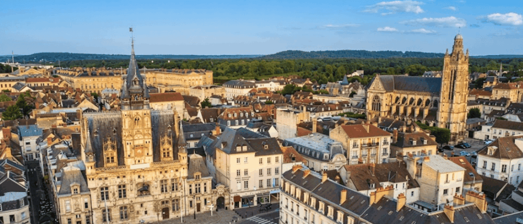 Une vue aérienne en grand-angle de la place de l'Hôtel de Ville de Compiègne par une journée ensoleillée.